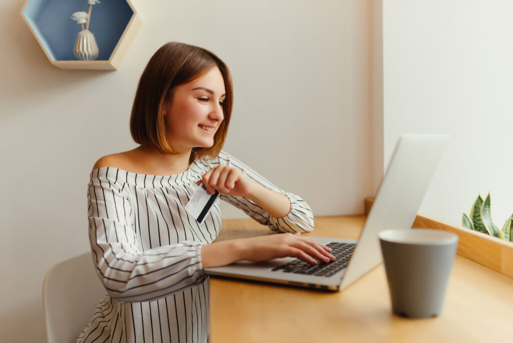 Young Happy Female Holding Credit Card And Using Laptop Computer 1024x684